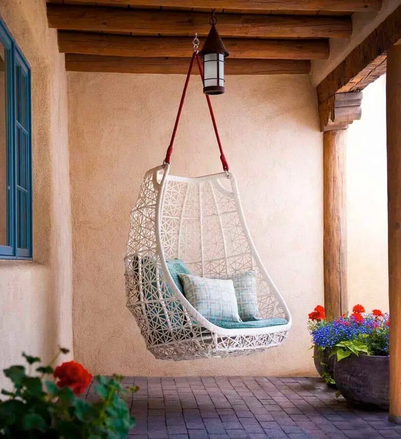 Cadeira de balanço suspensa para varanda rústica decorada com vasos de chão Foto One Kindesign