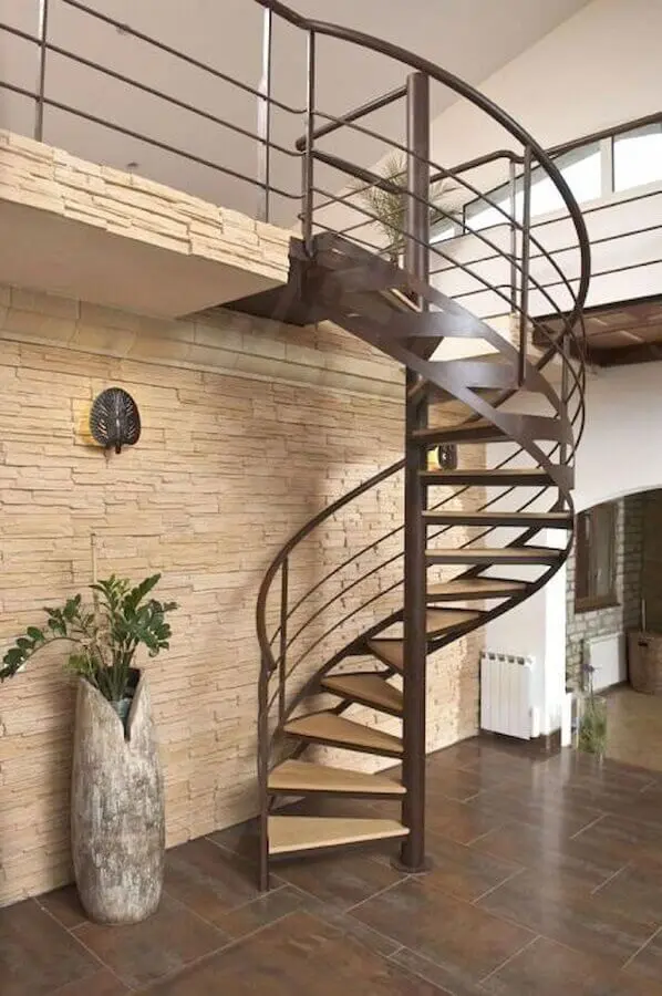decoração com parede de pedra e escada espiral de ferro e madeira Foto Pinterest