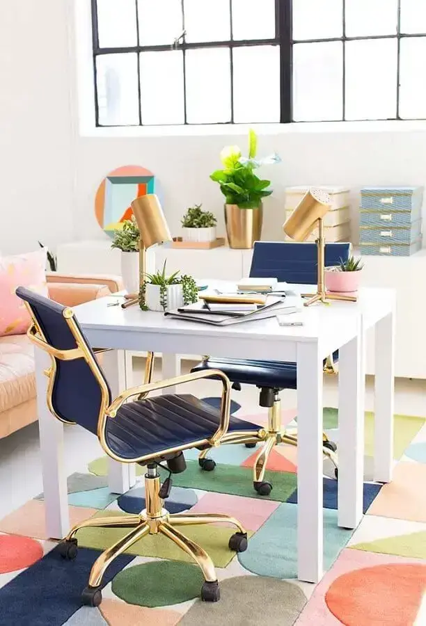 Decoração de home office pequeno na sala com cadeiras azuis e douradas