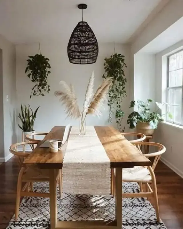 luminária preta para sala de jantar decorada com vasos de plantas e mesa de madeira Foto Pinterest
