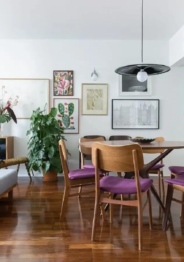 luminária simples para sala de jantar decorada com quadros de parede e cadeira estofada roxa Foto Histórias de Casa