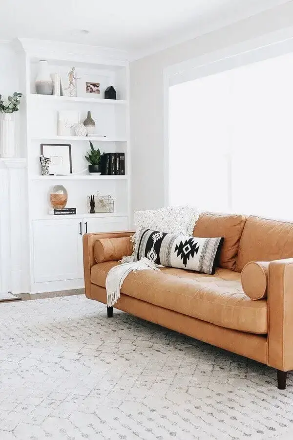 objetos de decoração para estante de sala branca decorada com sofá de couro caramelo Foto Pinterest
