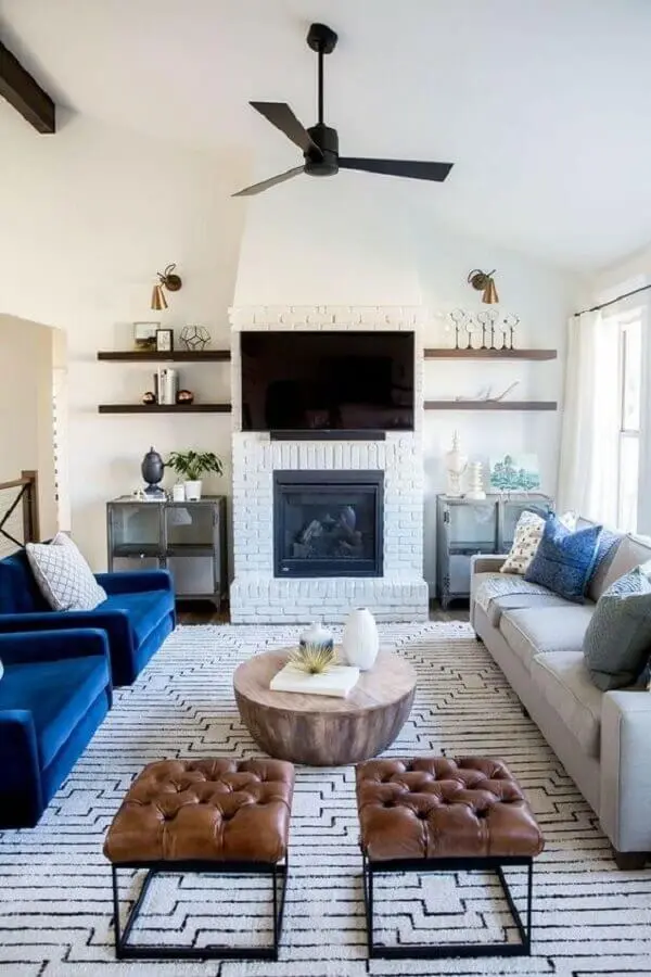poltrona azul para decoração de sala branca com lareira rústica Foto Arquitrecos