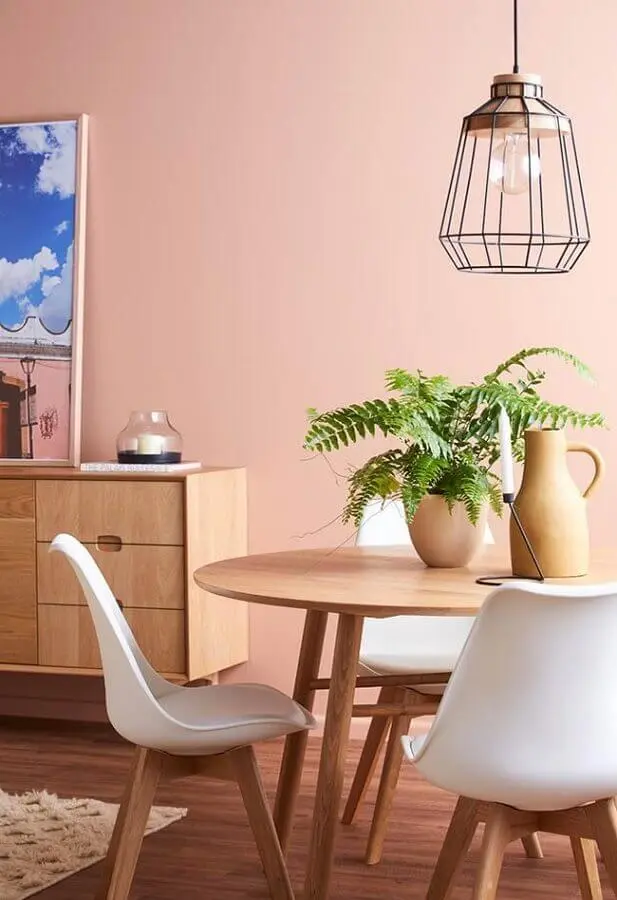 sala de jantar decorada com mesa redonda de madeira e parede rosa chá Foto Pinterest