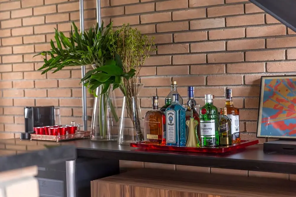 A bandeja bar organiza diferentes garrafas e utensílios de bar sobre o móvel. Foto: JP Image
