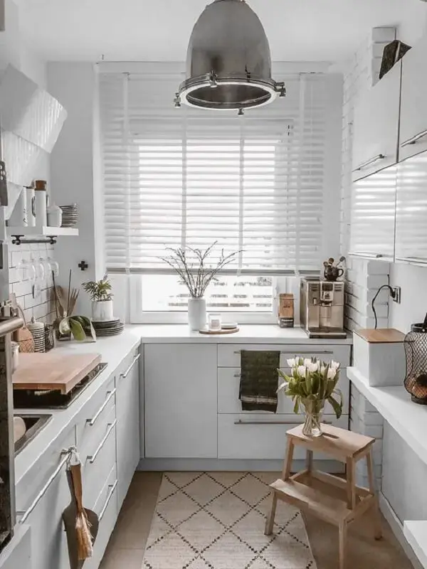 A persiana de madeira branca se mistura a decoração clean da cozinha. Fonte: Pinterest
