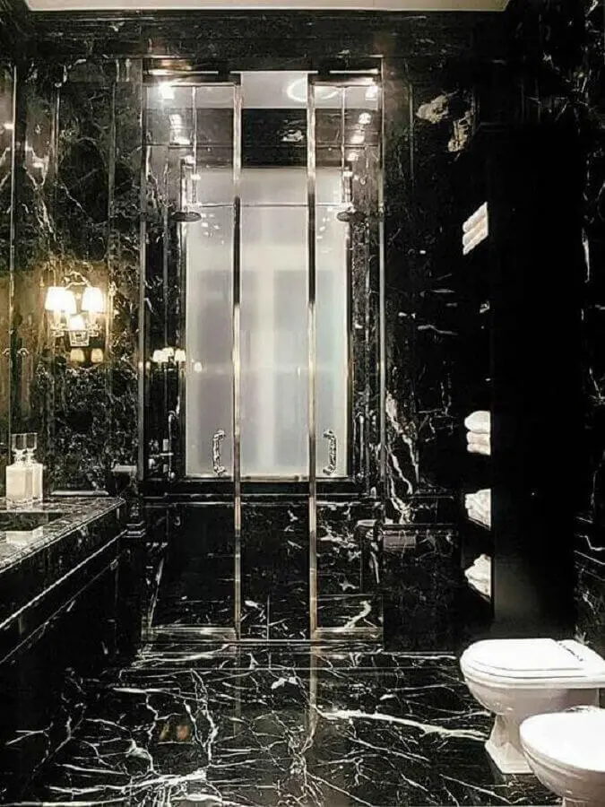 Banheiro de mármore preto com box de vidro