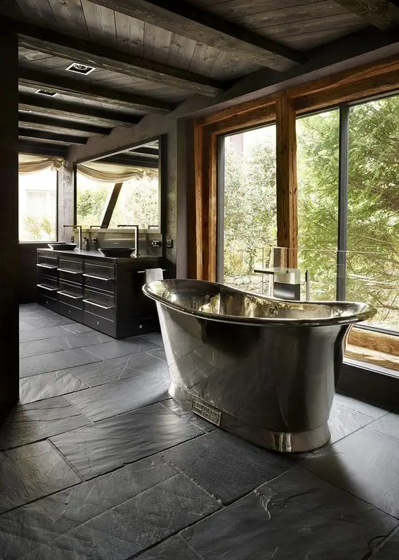 Banheiro com piso de ardósia preta e banheira de ferro