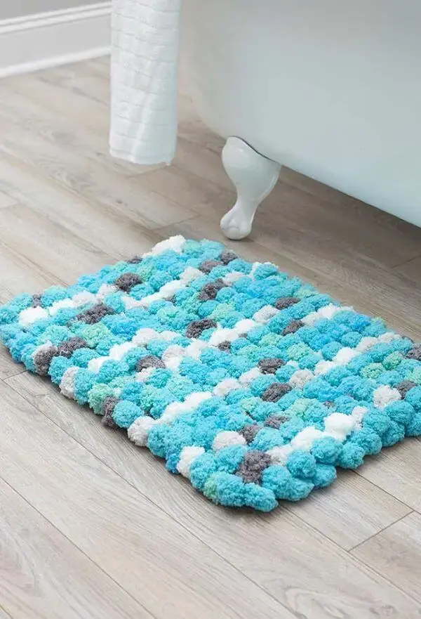 Banheiro com tapete de lã em tons de azul e branco