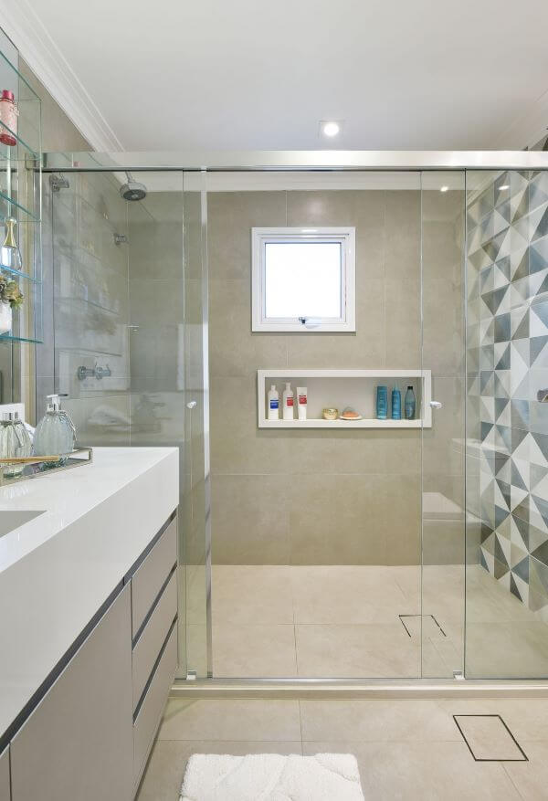 Banheiro revestido com piso porcelanato e bancada de quartzo branco para pia esculpida