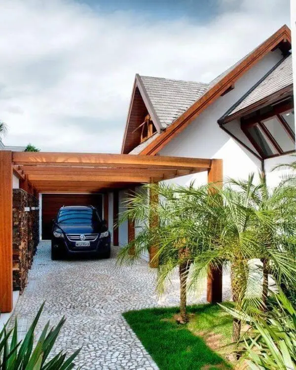 Casa com cerâmica para garagem coberta por pergolado de madeira