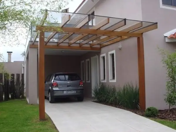 Casa com cerâmica para garagem e pergolado de vidro para proteger o automóvel