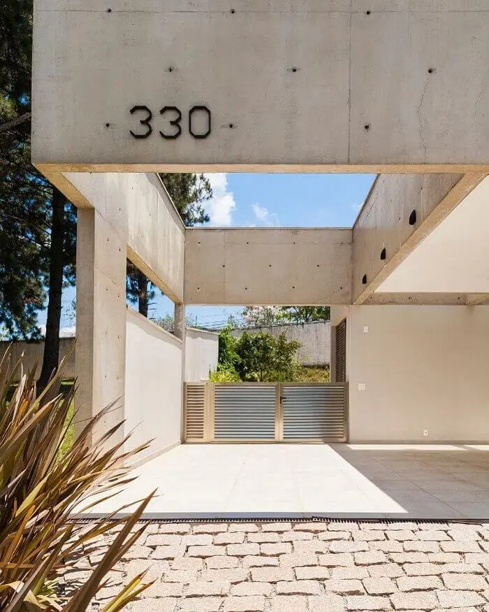 Casa moderna com cerâmica para garagem em bege e piso de pedra