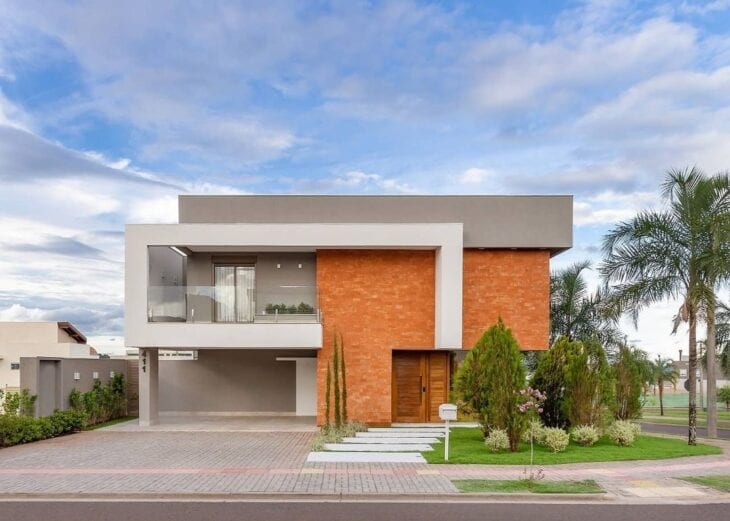 Casa moderna com cores para fachada cinza e branca e revestimento de tijolinho