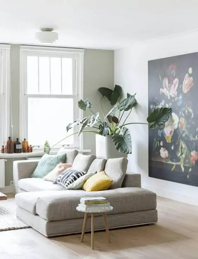 Combinação de almofadas para sofá cinza em sala branca decorada com planta grande Foto Media Jungle