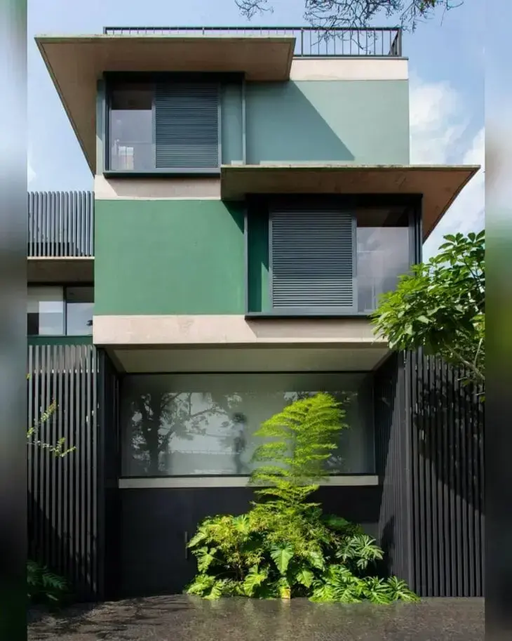Cores para fachadas de casas na cor verde com portão de ferro e plantas
