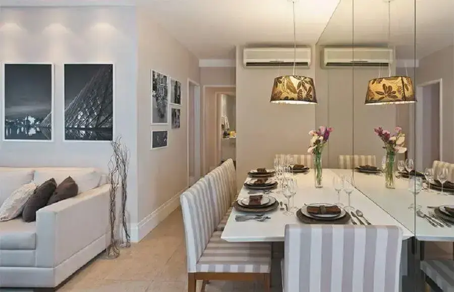 Cores para sala de jantar pequena decorada com parede espelhada e integrada à sala de estar Foto Guto Amorim