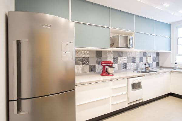 Cozinha com bancada de quartzo branco e armários azul claro