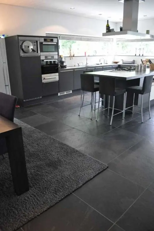 Cozinha com piso de ardósia preta e móveis cinza 