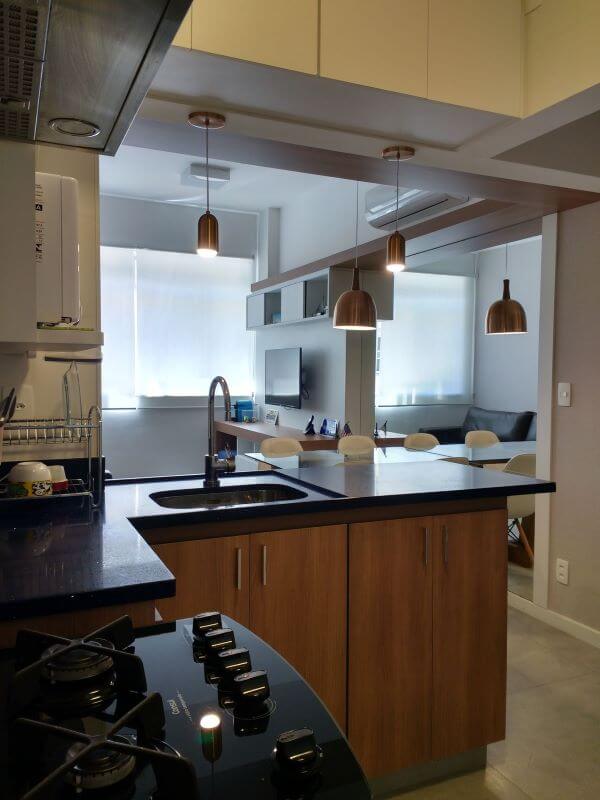 Cozinha integrada com a sala dividida pela bancada de quartzo preto