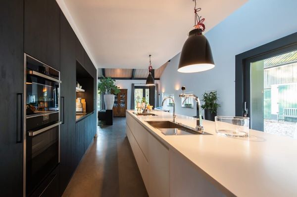 Cozinha luxuosa com bancada de quartzo branco e armários pretos planejados