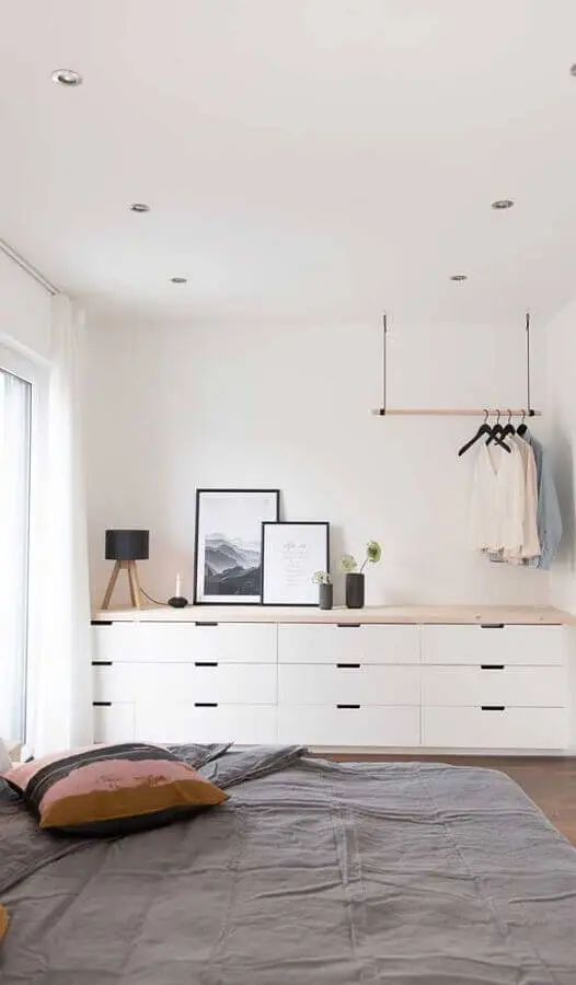 Cômoda branca grande para quarto de casal minimalista decorado com cabideiro de teto Foto Pinterest