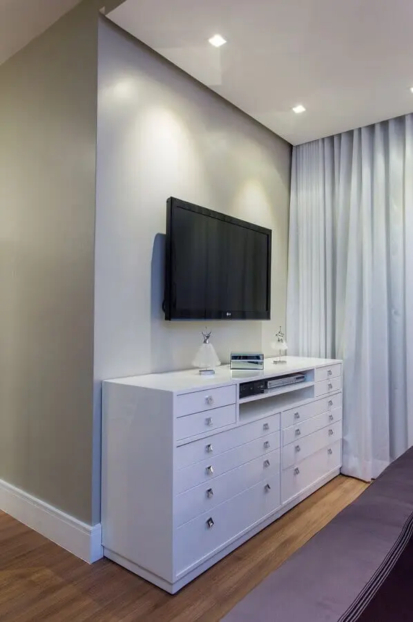 Cômoda branca para quarto decorado em cores claras com TV na parede Foto Bruno Sgrillo