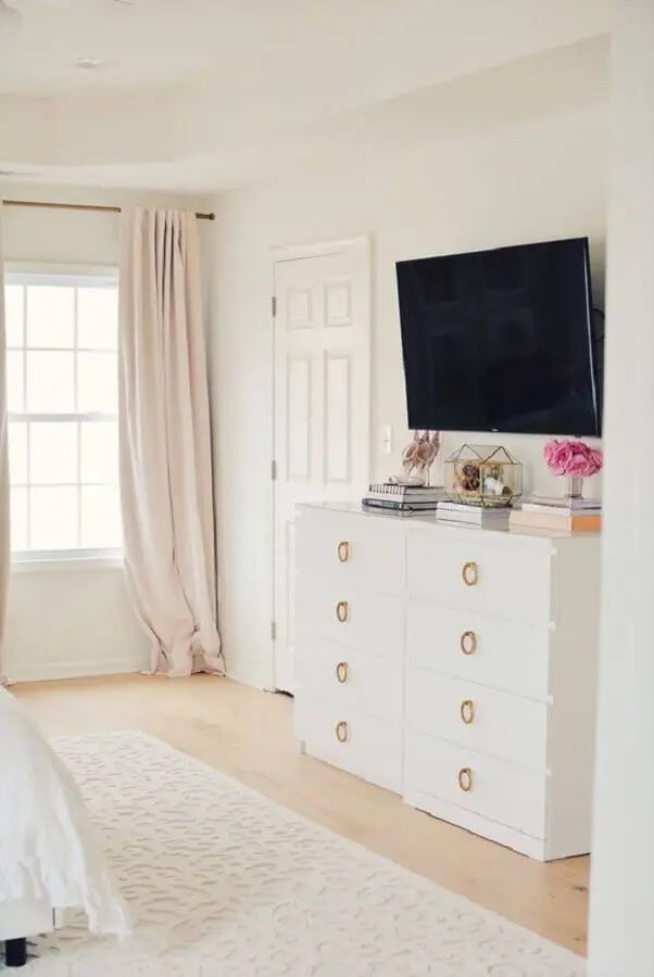 Cômoda branca para quarto grande decorado com TV na parede Foto Pinterest