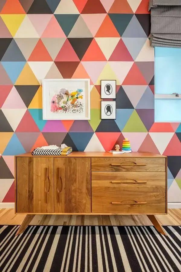 Cômoda de madeira para quarto decorado com papel de parede colorido e tapete listrado Foto Upper Terrace Nursery