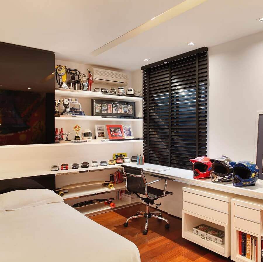 Decoração de quarto pequeno masculino com escrivaninha de canto e persiana preta Foto Juliana Affonso Arquitetura