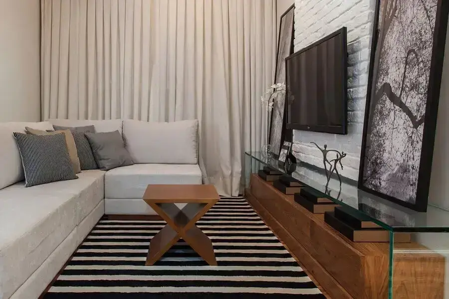 Decoração clean com cores para sala pequena com tapete preto e branco e sofá de canto Foto Sesso & Dalanezi Arquitetura+Design
