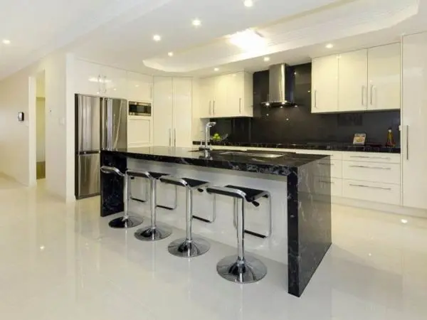 Decoração de cozinha branca com bancada preta de mármore