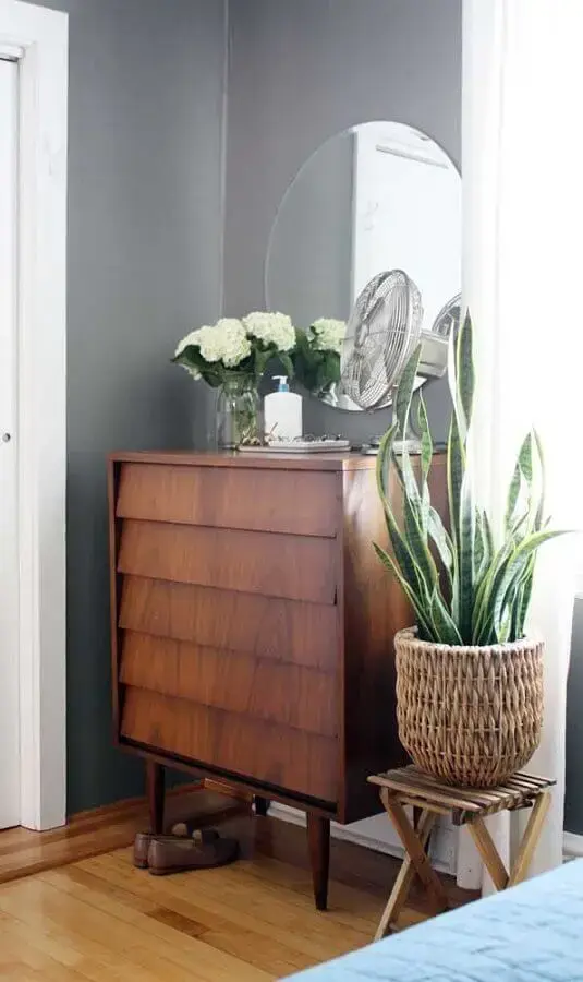 Decoração de quarto cinza com cômoda de madeira e espelho redondo sem moldura Foto Decor Fácil