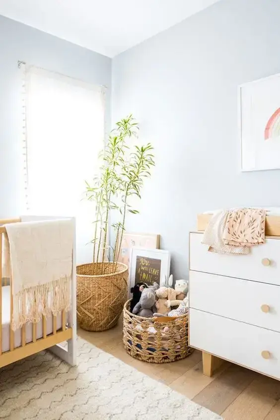 Decoração de quarto de bebê moderno com móveis de madeira e parede azul