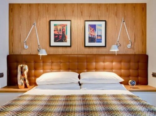 Decoração de quarto de casal com cabeceira de couro cor caramelo e parede de madeira Foto Casa de Valentina