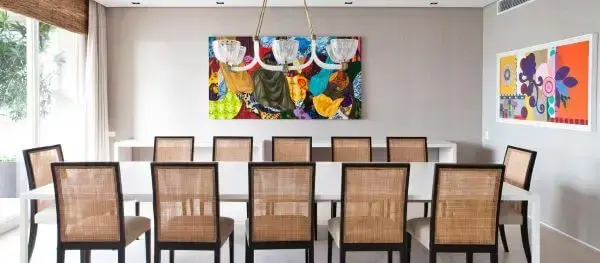 Decoração de sala moderna com mesa de jantar branca e cadeiras de palha