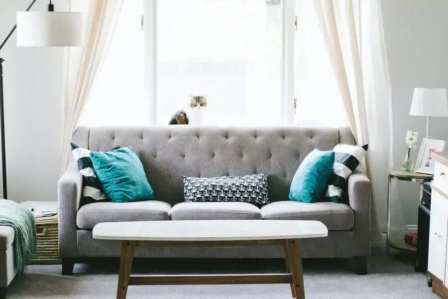 Decoração para sala de estar com abajur de piso e almofadas decorativas para sofá cinza Foto Unsplash