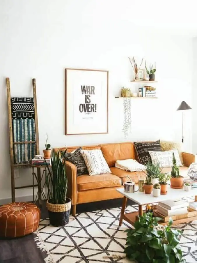 Decoração simples para sala branca com sofá cor caramelo e vasos de plantas Foto Archzine