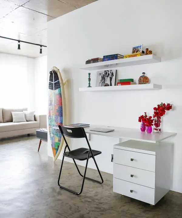 Escrivaninha suspensa e gaveteiro branco decoram o ambiente. Projeto de Buji Decoração Reuso