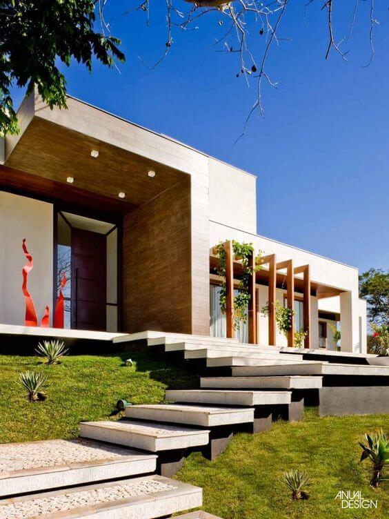 Fachada de casa moderna com revestimento de madeira e escada de pedra