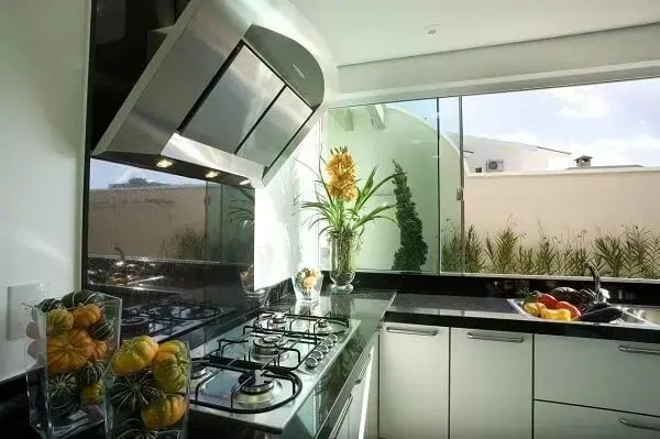 Feng Shui cozinha: espelhos e revestimento espalhados podem expandir o ambiente e trazem boas energia, desde que o espaço se mantenha organizado. Projeto de Aquiles Nicolas Kílaris