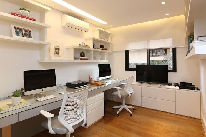 Home office compartilhado com gaveteiro branco. Projeto de Hildebrand Silva Arquitetura