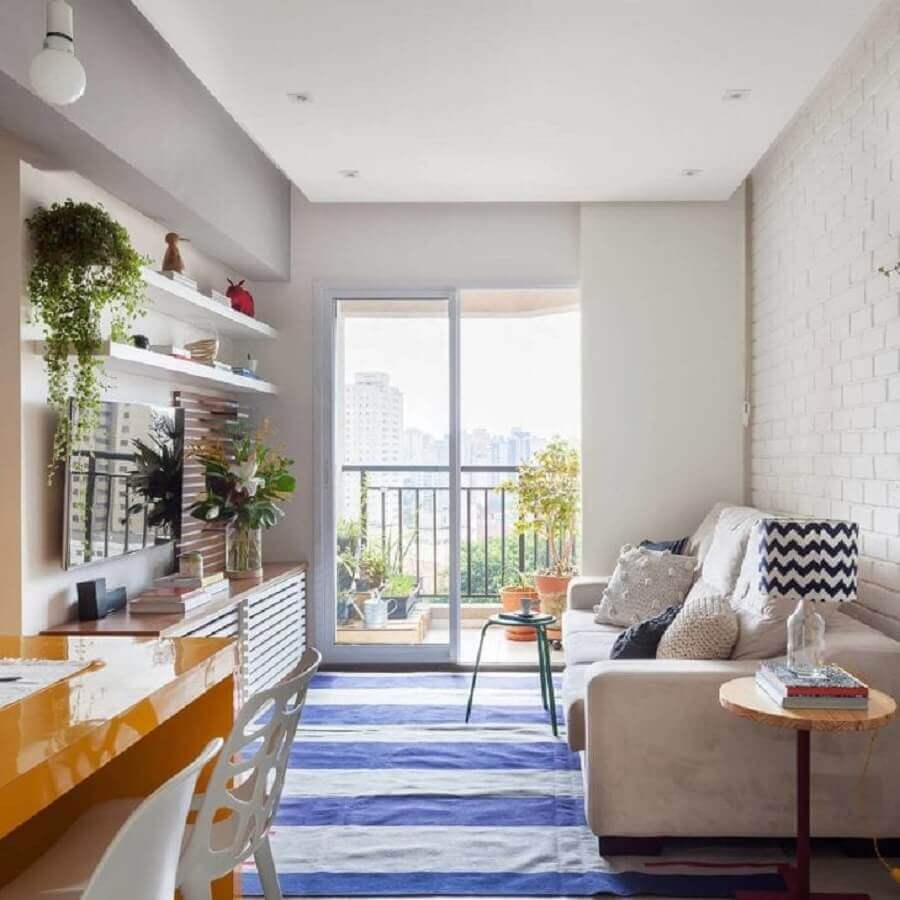 Ideia de cores para sala de estar pequena decorada com tapete listrado azul e branco Foto Tria Arquitetura