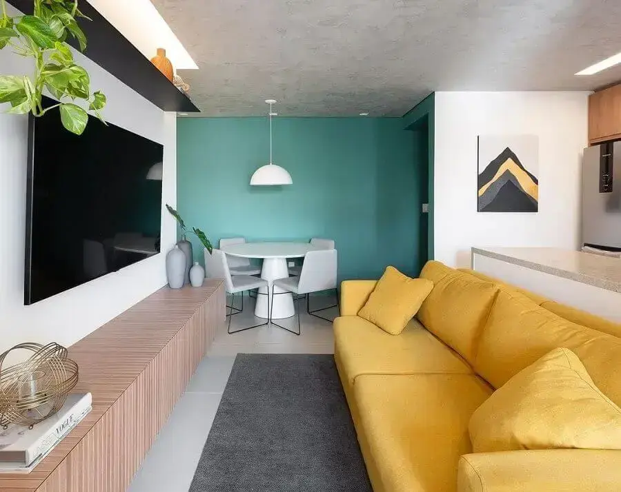 Ideia de cores para sala pequena e moderna decorada com sofá amarelo e parede azul Foto Fantato Nitoli