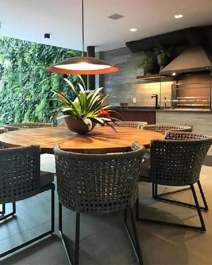 Lustre para área gourmet externa decorada com jardim vertical e mesa redonda  Foto Casa de Valentina