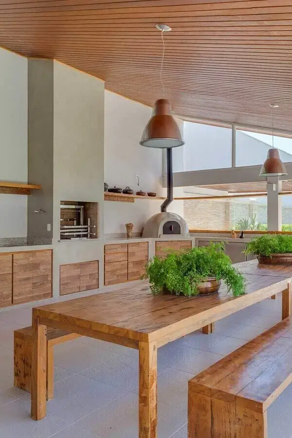 Lustre para área gourmet externa decorada com móveis de madeira e forno de pizza Foto Pinterest