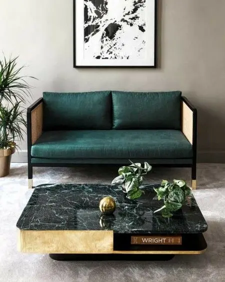 Mesa de centro de mármore preto e sofá verde