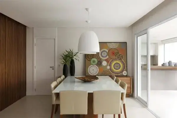 Mesa de jantar quadrada branca com cadeira bege e quadros geométricos