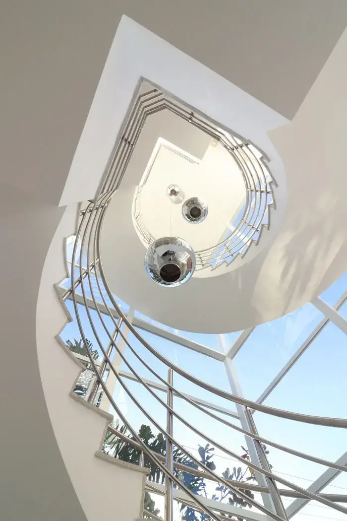 Modelo de lustre para escada pé direito alto metálico. Projeto de RAWI Arquitetura + Design