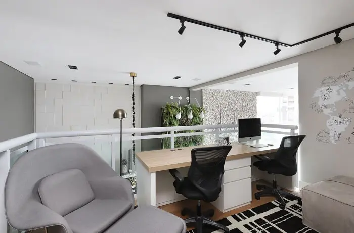 O gaveteiro branco delimita o espaço de cada usuário da escrivaninha. Projeto de Inside Arquitetura e Design